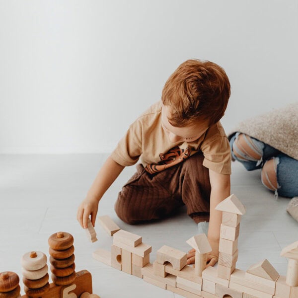 Engaging child playing with wooden blocks, fostering creativity and developmental skills.