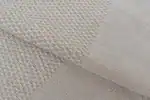 Soft beige woven fabric with a textured pattern, ideal for upholstery and home decor.