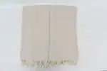 Soft beige woven fabric with fringed edges, neatly folded on a white background.