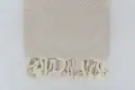 Soft beige woven textile with tassel fringe, ideal for home decor or cozy accents.