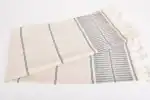 Soft woven textile with striped pattern and fringed edges, ideal for home decor or cozy accents.