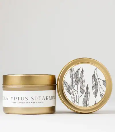 Eucalyptus Spearmint soy wax candle in a sleek white and gold tin, perfect for home ambiance and rel.