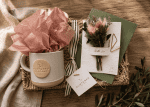 Thoughtful morning gift bundle featuring a linen Nurtured signature ceramic mug, plantable wildflower greeting card with dried floral bouquet, and woven seagrass decorative tray styled for cozy mornings and elevated gifting.