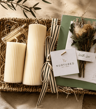 Luxury candle gift bundle featuring hand-poured ribbed soy wax pillar candles, a woven seagrass decorative tray, and a plantable wildflower greeting card styled for cozy home décor and elevated gifting.