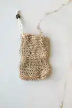 Natural jute soap saver pouch with drawstring closure designed to create rich lather, gently exfoliate skin, and extend the life of soap bars in an eco-friendly bath routine.