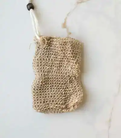 Natural jute soap saver pouch with drawstring closure designed to create rich lather, gently exfoliate skin, and extend the life of soap bars in an eco-friendly bath routine.