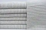 Soft, patterned fabric in neutral tones, neatly folded and draped for display.