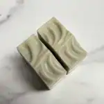 Handmade natural soap with elegant swirl design on a white marble surface.