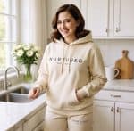 Nurtured Collective hoodie and sweatpants in a cozy kitchen setting, promoting sustainable and comfo.
