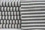 Black and white striped fabric rolls with geometric patterns for textile design.