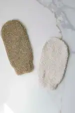 Soft exfoliating bath mitts in neutral tones for skincare routines.