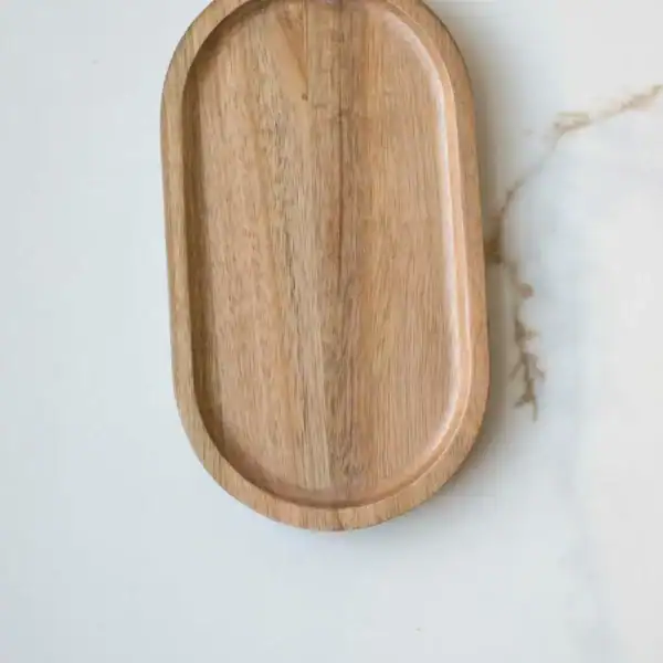 Wooden serving tray on white marble surface, minimalist kitchen accessory.