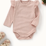 Organic cotton baby bodysuit in Blush Petal pink with flutter sleeves, long sleeves, and ribbed knit texture.